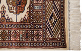 The fine Bokhara rug's intact side cord selvage, geometric border, and soft ivory wool fringe.