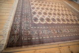 Vintage Bokhara rug's tight geometric border in navy, terracotta, ivory with crisp fringe.