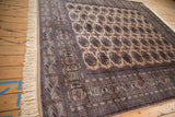Plush vintage Bokhara rug with camel field, exhibiting detailed geometric borders and signature gul medallions.