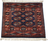 An angled view of a fine Bokhara rug showing its geometric gul pattern and plush pile.