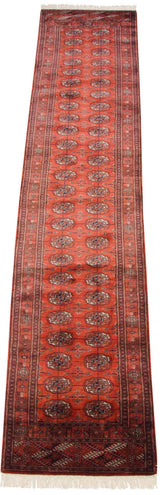 A view of the fully secured end, geometric border, and white fringe on a vintage Bokhara runner.