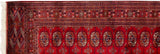 Plush cherry red Bokhara runner corner with ivory fringe and fine geometric borders.
