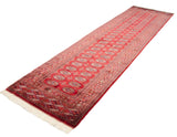 Intact ivory fringe and geometric gul patterns on the vintage Bokhara rug end.