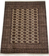 Angled perspective of a vintage Bokhara carpet's repeating gul medallions and intricate borders.