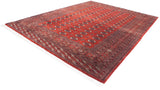 Vintage Bokhara carpet at an angle, displaying its lustrous brick-red pile and repeating gul medallions.