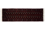 Repeating columns of traditional gul medallions in navy and ivory on a wine red Bokhara runner.
