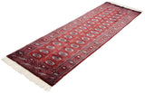 Angled full view of a Bokhara rug runner showing its repeating rows of gul medallions.
