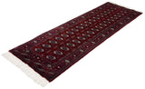 Angled view of a vintage Bokhara runner highlighting the lustrous sheen on its wine-red pile.
