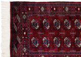 Corner of a fine Bokhara runner showing the plush wool pile, detailed gul motifs, and ivory fringe.