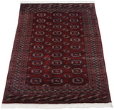 Full angled view of a vintage Bokhara carpet showcasing its lustrous red pile and intricate borders.