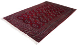Angled view of the entire vintage Bokhara carpet, showing its lustrous wine-red pile.