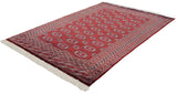Full angled view of a vintage Bokhara carpet showing its repeating gul medallions and lustrous wine-red pile.
