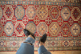 Geometric Moghan style guls in cherry red and sapphire blue on a Kazak design rug.
