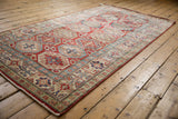 Moghan style Kazak motif with cherry red, sapphire blue, and ivory medallion guls.