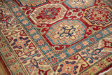 Cherry red, sapphire blue, and ivory geometric guls on a new Pakistani Kazak rug.