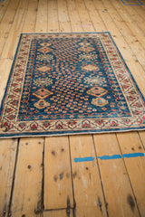 Pakistani Caucasian rug with indigo blue abrash field, playful motifs, and patterned ivory borders.