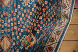 Colorful floral design elements scattered across the indigo blue field and ivory border.