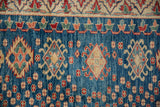 Abrash indigo field with diamond contours, enveloped hook and latch motifs, and florals.
