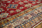Pakistani Caucasian rug detail: cherry red field with geometric motifs and saffron yellow border.