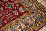 Pakistani Caucasian rug corner with cherry red field, ivory crab vine main border, and colorful geometric guards.