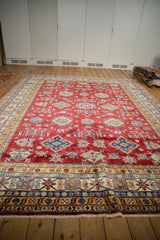 Cherry red Pakistani Caucasian rug showcasing geometric diamond motifs and a crab vine border.