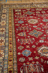 Pakistani Caucasian rug's red field with geometric medallions and ivory border.