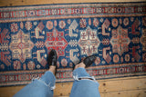 Sapphire blue Pakistani Caucasian design rug with geometric medallions and finned bird motifs.