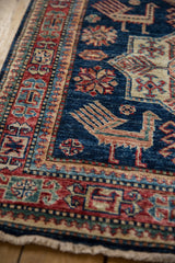 Cherry red geometric border and sapphire blue field with floral motifs on Pakistani runner.