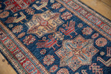 Geometric medallions, finned birds, and floral motifs in sapphire blue, cherry red, and pale gold.