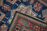 Hand-knotted Pakistani Caucasian runner corner, showing blue selvage and woven foundation.