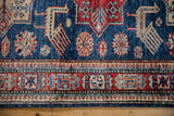 Cherry red and faded teal geometric border, with sapphire blue field and Akstafa-inspired bird motifs.
