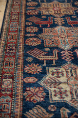 Hand-knotted runner's sapphire blue field with finned birds and cherry red geometric border.