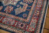 Close-up of geometric border and sapphire blue field with finned bird motifs on Caucasian runner.