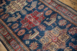 Sapphire blue field with cherry red quatrefoil medallion and pale gold finned bird motifs.