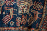 Textured hand-knotted pile revealing finned bird and quatrefoil patterns. Sapphire blue, cherry red, ivory.