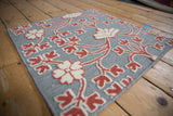 Raised hand-knotted ivory and raspberry floral pile over a silver flatweave base.