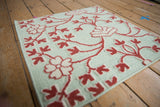 Textured view of raised raspberry and ivory floral pile on a honeydew green flatweave.