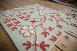 Mixed-weave texture of raised raspberry red motifs on a honeydew green flatweave rug.
