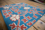 Raised hand-knotted raspberry red and ivory florals on a contrasting sky blue flatweave.