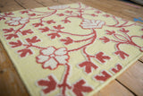 Angled view of the raised raspberry red and ivory floral pile on a lemon-lime flatweave.
