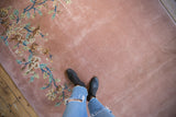 Plush dusty rose Art Deco carpet with ornate floral vines, shown with a person walking.