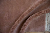 Plush dusty rose blush pile and intact side cord selvage of the vintage rug.