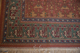 Geometric pistachio green and sky blue borders on vintage Lotto Soumac rug with ivory fringe.