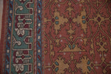 Geometric pistachio green border, dusty gold Lotto Soumac design on madder red Indian rug.