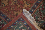 Vintage Indian Lotto Soumac carpet detail, showing madder red field, pistachio green border, blue accents, and ivory fringe.