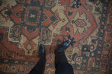 Delicate vinery and palmettes in madder red and dusty teal on a vintage Indian Serapi Soumac carpet.
