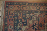 Corner of vintage Indian Serapi Soumac rug, madder red field with teal floral border and fringe.