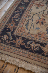 Traditional Indian Serapi Soumac rug border detail featuring dusty navy, terracotta vinery, and ivory field.