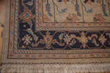 Corner of vintage Serapi Soumac rug, dusty navy border, ivory field, madder root vinery.
