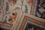 Hand-woven fringe, intact selvage, and terracotta floral vinery on folded Serapi Soumac rug.